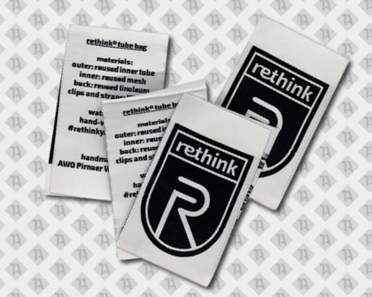 Label gewebt mit Laserschnitt schwarz weiß rethink Schriftzug