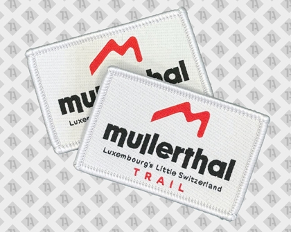 Zwei weiße Mullertal Trail Aufnäher mit rotem Logo und schwarzer Schrift
