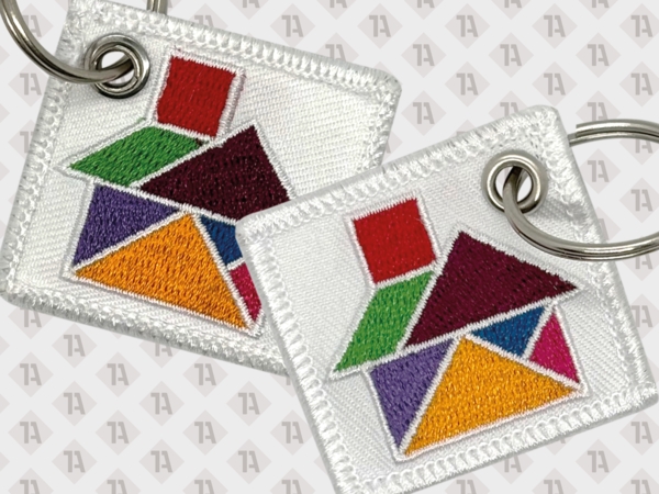 Gestickter Schlüsselanhänger mit buntem Tangram-Motiv auf weißem Hintergrund