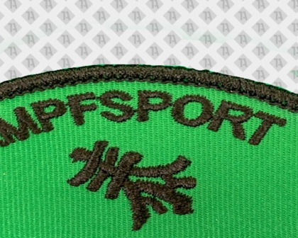 Gestickter Karate Aufnäher mit Kettelrand und schwarzer Schrift auf grünem Stoff