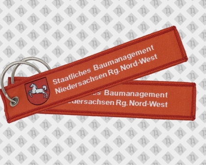 Gewebter Schlüsselanhänger mit Kettelrand Ring und Öse rot Gemeinde