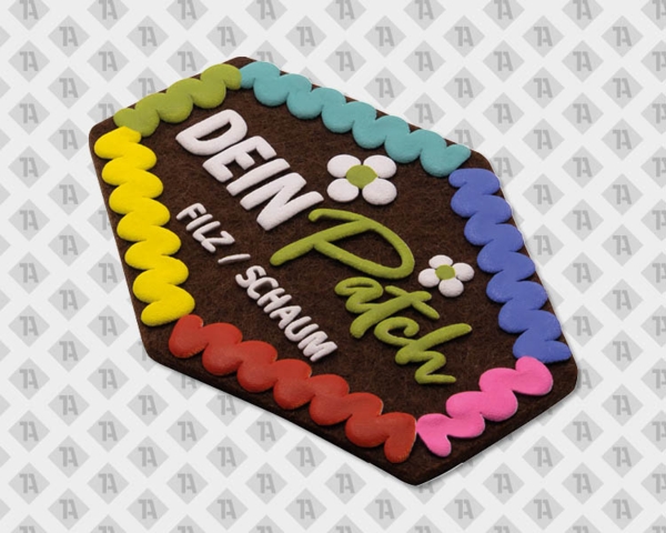 Aufnäher aus Filz mit bunten Wellenkanten, Blumen-Motiv und Text „Dein Patch Filz Schaum“.