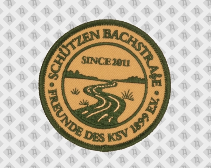 Runder Grün-Beige Aufnäher „Schützen Bachstraße – Freunde des KSV 1899 e.V.“ mit Flusslandschaft und Text „Since 2011“