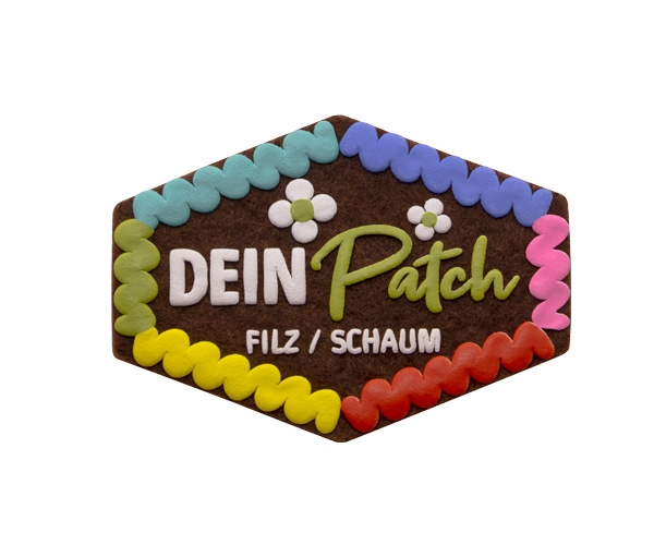 Beispielpatch eines Filzaufnähers mit geschäumten Elementen - Optik wie ein Lebkuchenherz: brauner Untergrund und verschiedenfarbige Schriften und Formen