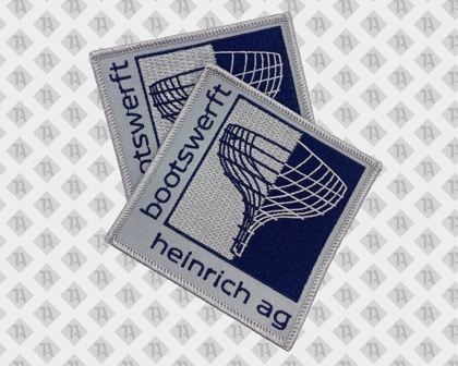 Eckiger gestickter Aufnäher Patch mit Kettelrand in grau blau von Heinrich AG Bootswerft Firmen