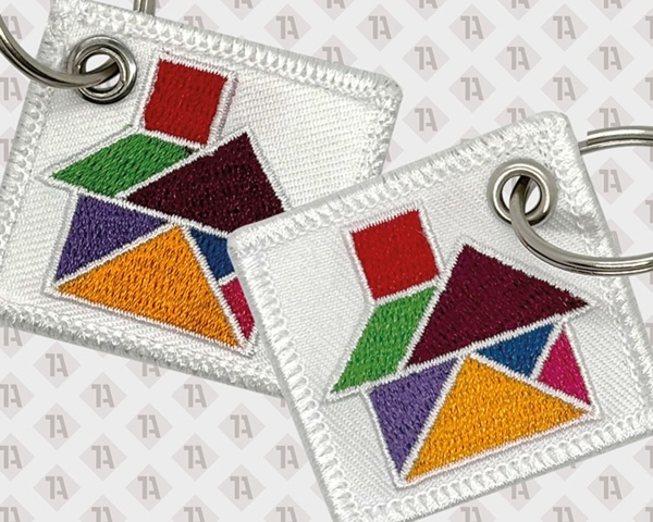 Gestickter Schlüsselanhänger mit buntem Tangram-Motiv auf weißem Hintergrund