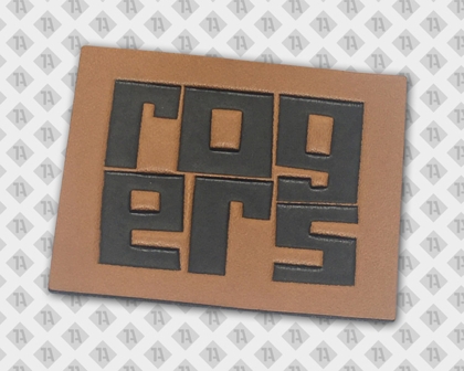 Rechteckiger Lederpatch mit geprägtem ROGERS Schriftzug in Schwarz auf hellbraunem Hintergrund.