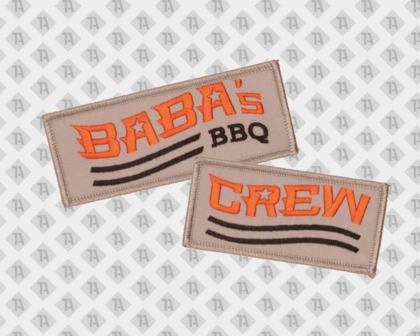 Zwei beige Rechteck-Patches mit orangefarbener Schrift „BABA’s BBQ“ und „CREW“ sowie schwarzen Linien für BBQ-Teamkleidung