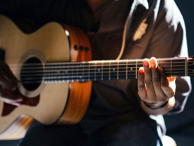 Stimmungsbild für Infoseite Musiker - eine Gitarrenspielering an der Gitarre