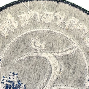 Rückseite eines gestickten Patches mit sichtbaren Stickfäden zur Befestigung durch Aufnähen