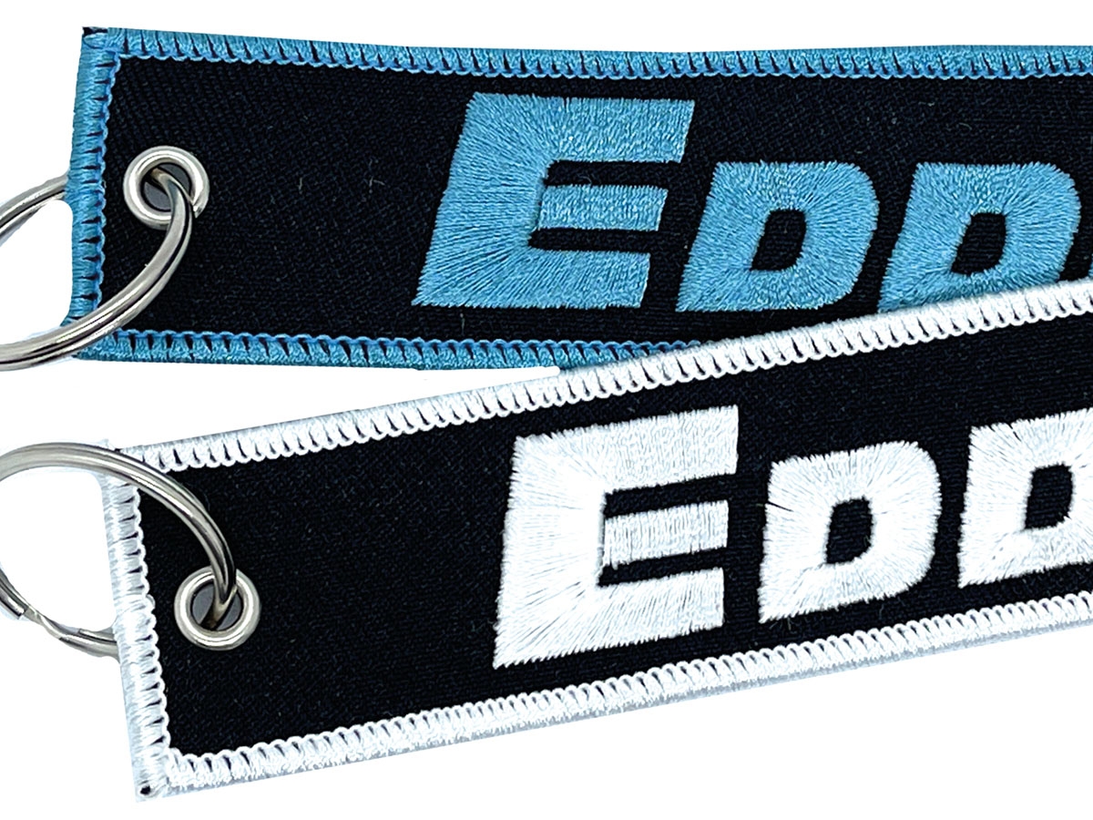 Schlüsselanhänger mit gesticktem EDD-Logo in Blau und Weiß auf schwarzem Grund