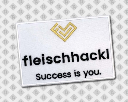 Eckiger Patch Aufnäher gestickt mit gesticktem Rand fleischhackl weiß schwarz metallicgold Firmen