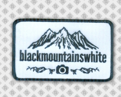 Minimalistischer Aufnäher für Outdoor-Fotograf:innen – „blackmountainswhite“-Motiv in Weboptik