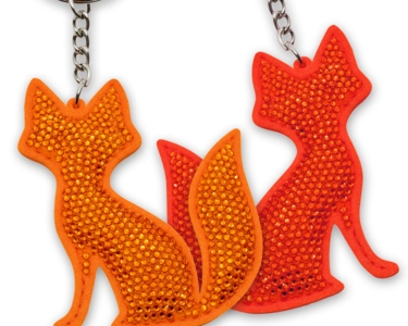 ein orangener und ein roter stilisierter Fuchs als Lederschlüsselanhänger mit gepolsterten Formen