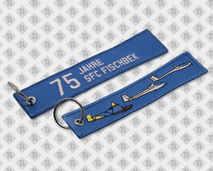 Blauer Anhänger mit „75 Jahre SFC Fischbek“ und mehreren gestickten Segelflugzeugen.