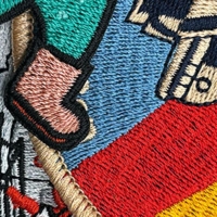Nahaufnahme bestickter Patches mit buntem Standard-Stickgarn – detailreiche Stickerei mit kräftigen Farben.