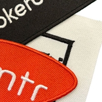 Standardhintergrund in verschiedenen Farben – schwarzes, weißes und rotes Patch mit gestickten Logos und Schriftzügen