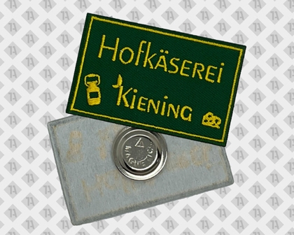 Grüner Namenspatch mit Magnet für Hofkäserei Kiening – gelbe Stickerei und Käsesymbol
