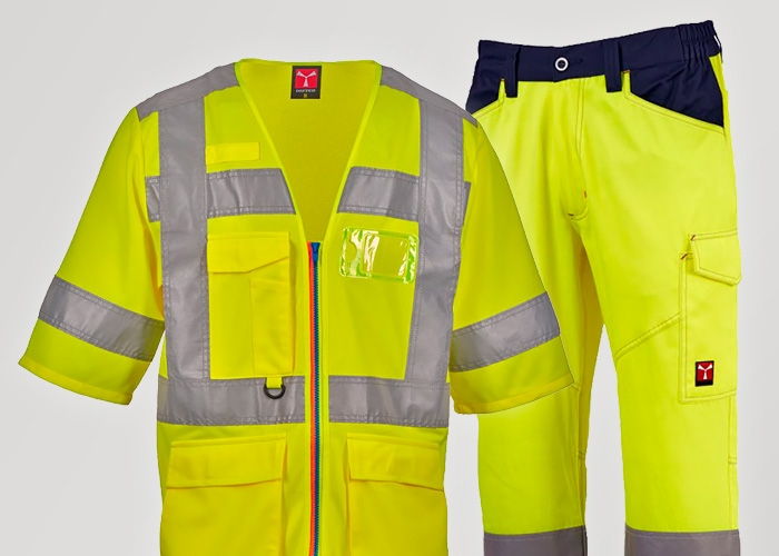 Eine gelbe Warnweste und eine gelbe Warnschutzhose mit reflektierenden Streifen stehen vor hellem Hintergrund nebeneinander.