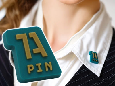 Nahfaufnahme unseres 1A-Gummipins mit einem Foto eines Modells mit Hemd und Weste