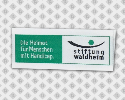 Label gewebt Loop Fold Laserschnitt Stiftung Waldheim grün weiß